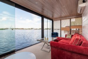 Czerwona kanapa w nowoczesnym salonie z widokiem na jezioro. 